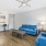 Model living room at our apartments in Orlando, featuring wood grain floor paneling and blue couches 