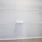 Walk in closet at our apartments in Orlando, featuring beige carpet and white clothes racks with shelves.