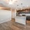 Model kitchen at our apartments in Orlando, featuring wood grain floor paneling and granite counter tops. 