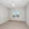 Empty bedroom at our apartments in Orlando, FL, featuring beige carpet and beige walls with overhead lights