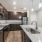 Model kitchen at our apartments in Orlando, featuring wood grain floor paneling and granite counter tops. 